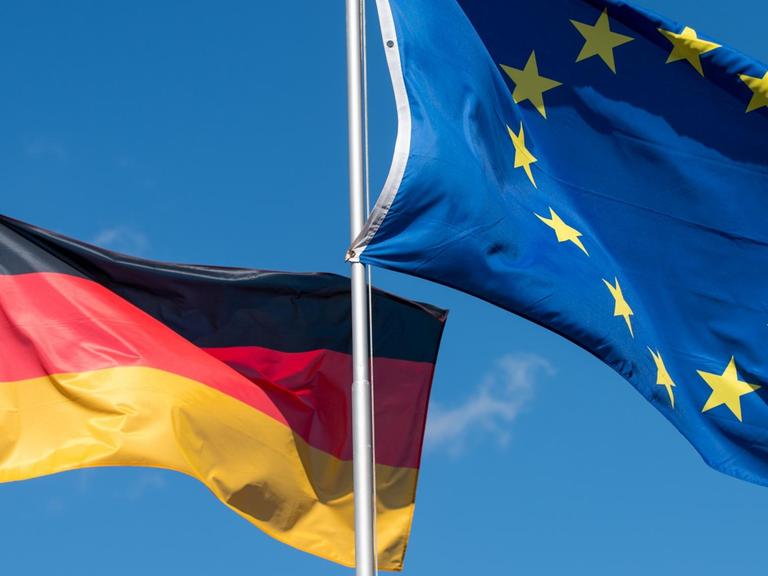 Die Nationalfahne von Deutschland und die Flagge der Europäischen Union wehen im Wind