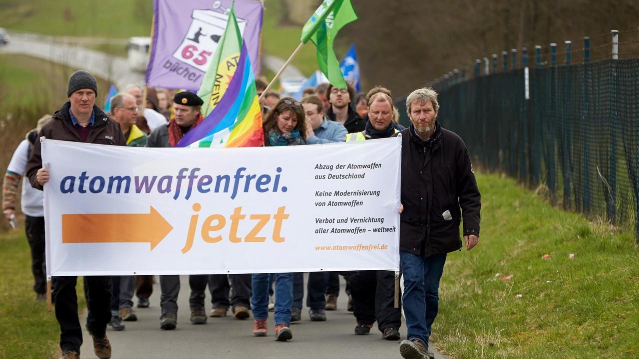 Teilnehmer des Ostermarschs am Fliegerhorst Büchel laufen am 06.04.2015 am Außenzaun des Luftwaffen-Fliegerhorsts in Büchel vorbei.Sie demonstrieren für den Abzug der dort gelagerten amerikanischen Atomwaffen. Foto: Thomas Frey/dpa Teilnehmer des Ostermarschs am Fliegerhorst Büchel laufen am 06.04.2015 am Außenzaun des Luftwaffen-Fliegerhorsts in Büchel vorbei.Sie demonstrieren für den Abzug der dort gelagerten amerikanischen Atomwaffen. Foto: Thomas Frey/dpa