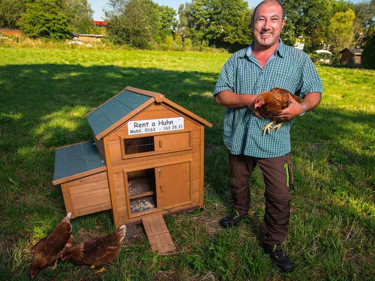 Michael Lüft steht auf seinem Hühnerhof in Seligenstadt (Hessen) neben einem Hühnerstall, den er samt Hühnern vermietet.