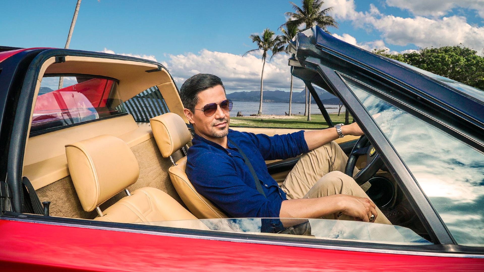 Jay Hernandez als Thomas Magnum sitzt in einem roten Ferrari auf einem Filmstill des Serien-Remakes "Magnum P.I.", das ab 17.4.2019 auf VOX zu sehen ist.