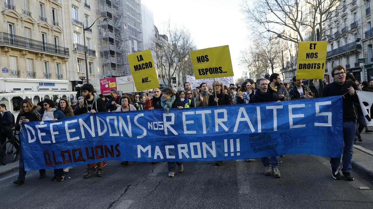 Demonstrierende in Paris halten ein blaues Transparent mit der Aufschrift "Defendons nos Retraites". 
