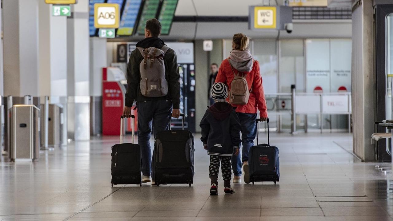 Eine Familie geht mit Koffern durch das ansonsten menschenleeren Terminal am Flughafen Tegel. Eine Familie geht mit Koffern durch das ansonsten menschenleeren Terminal am Flughafen Tegel.