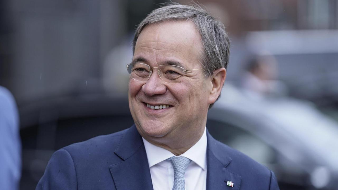 Ein Mann in dunkelblauem Anzug und grauem Haar lächelt links am Betrachter vorbei. Es handelt sich um CDU-Politiker Armin Laschet.
