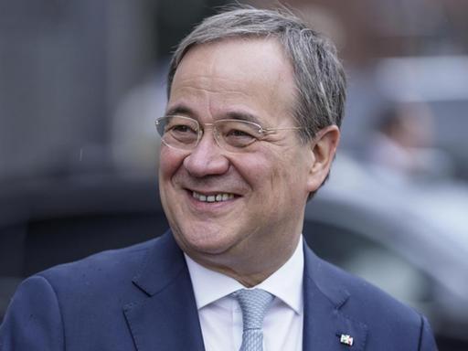 Ein Mann in dunkelblauem Anzug und grauem Haar lächelt links am Betrachter vorbei. Es handelt sich um CDU-Politiker Armin Laschet.