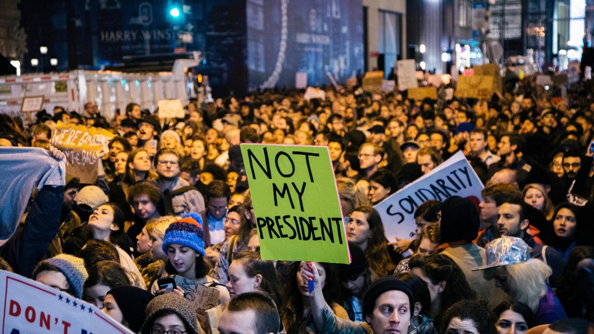 Menschen nehmen an einer Demonstration gegen den zukünftigen Präsidenten der USA, Donald Trump, in New York teil. Menschen nehmen an einer Demonstration gegen den zukünftigen Präsidenten der USA, Donald Trump, in New York teil.