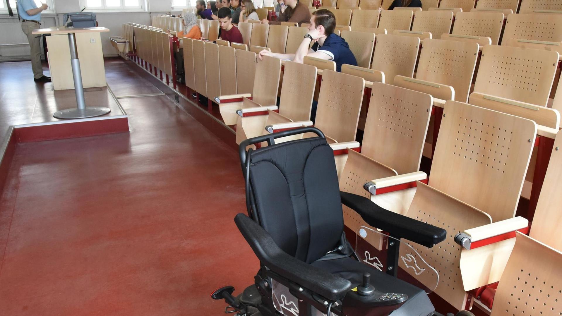 Ein Rollstuhl im Hörsaal: Viele Universitäten in Deutschland sind darauf noch nicht eingestellt. Für Menschen mit Behinderungen gibt es um Uni-Alltag immer wieder Hürden, die sie überwinden müssen.