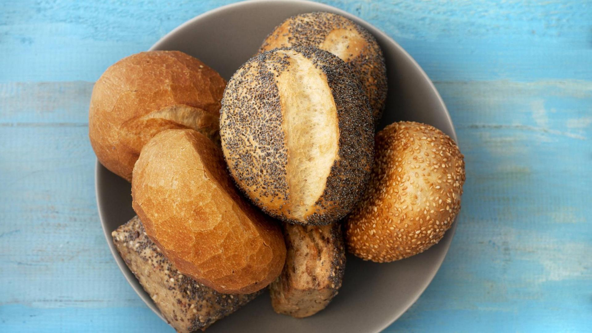 Eine Schale mit Körnerbrötchen, darunter auch ein Mohnbrötchen. Eine Schale mit Körnerbrötchen, darunter auch ein Mohnbrötchen.