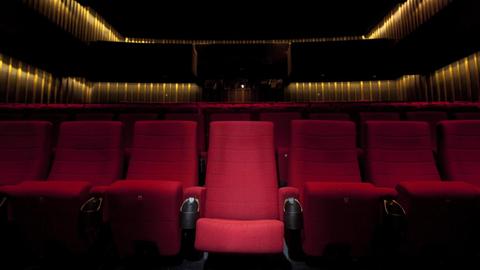 Erste Sitzereihe eines leeren Kinosaalls