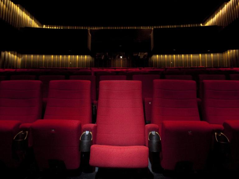 Erste Sitzereihe eines leeren Kinosaalls