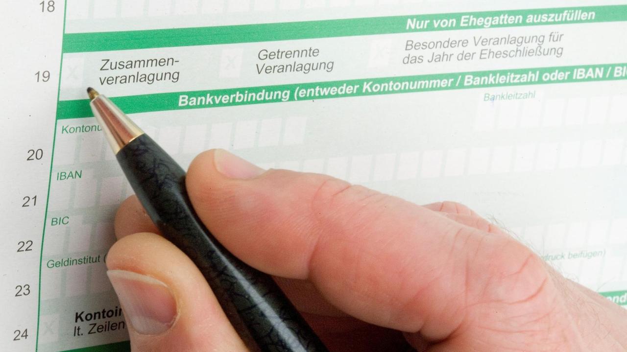 Ein Mann füllt ein Formular zur Steuererklärung aus (Symbolbild) Ein Mann füllt ein Formular zur Steuererklärung aus (Symbolbild)