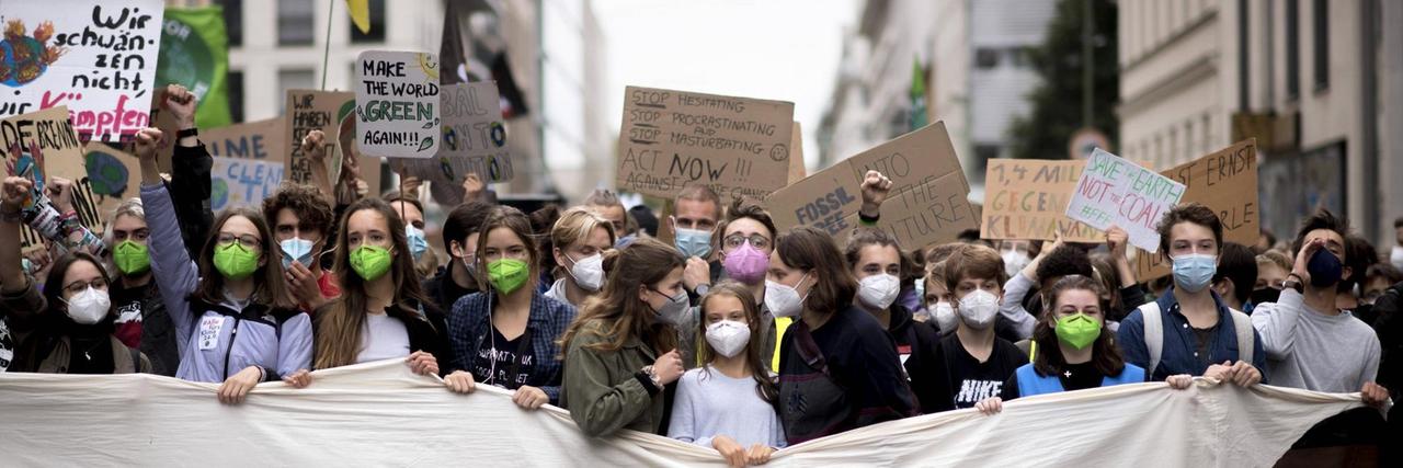 In Berlin demonstrieren viele junge Menschen gegen die Klimakrise. In der ersten Reihe steht Greta Thunberg hinter einem Banner mit der Aufschruft "Justice". In Berlin demonstrieren viele junge Menschen gegen die Klimakrise. In der ersten Reihe steht Greta Thunberg hinter einem Banner mit der Aufschruft "Justice".
