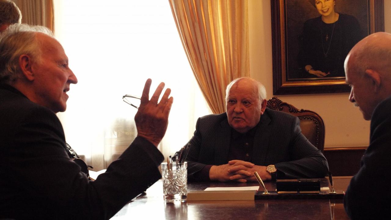 Regisseur Werner Herzog (links) und der Initiator von Glasnost und Perestroika, Michail Gorbatschow (Mitte), sitzen am Tisch