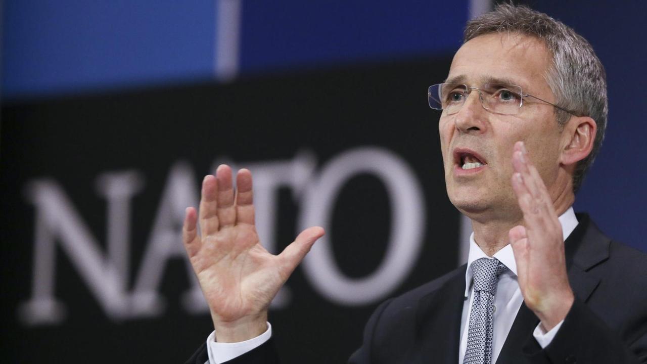 Stoltenberg spricht und gestikuliert im Nato-Presseraum. Im Hintergrund sieht man unscharf den "NATO"-Schriftzug. Stoltenberg spricht und gestikuliert im Nato-Presseraum. Im Hintergrund sieht man unscharf den "NATO"-Schriftzug.