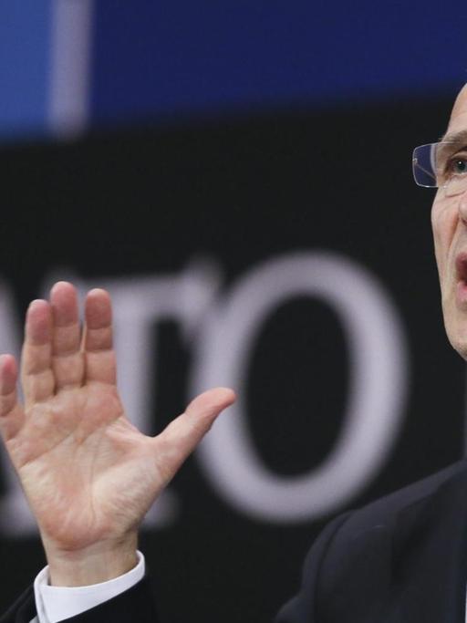 Stoltenberg spricht und gestikuliert im Nato-Presseraum. Im Hintergrund sieht man unscharf den "NATO"-Schriftzug.