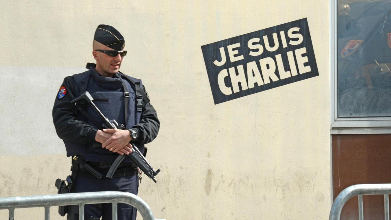 Ein bewaffneter Polizist bewacht in Paris den Eingang zur Redaktion der Satirezeitschrift "Charlie Hebdo", die am 7. Januar 2015 Opfer eines islamistisch motivierten Terroranschlag wurde.