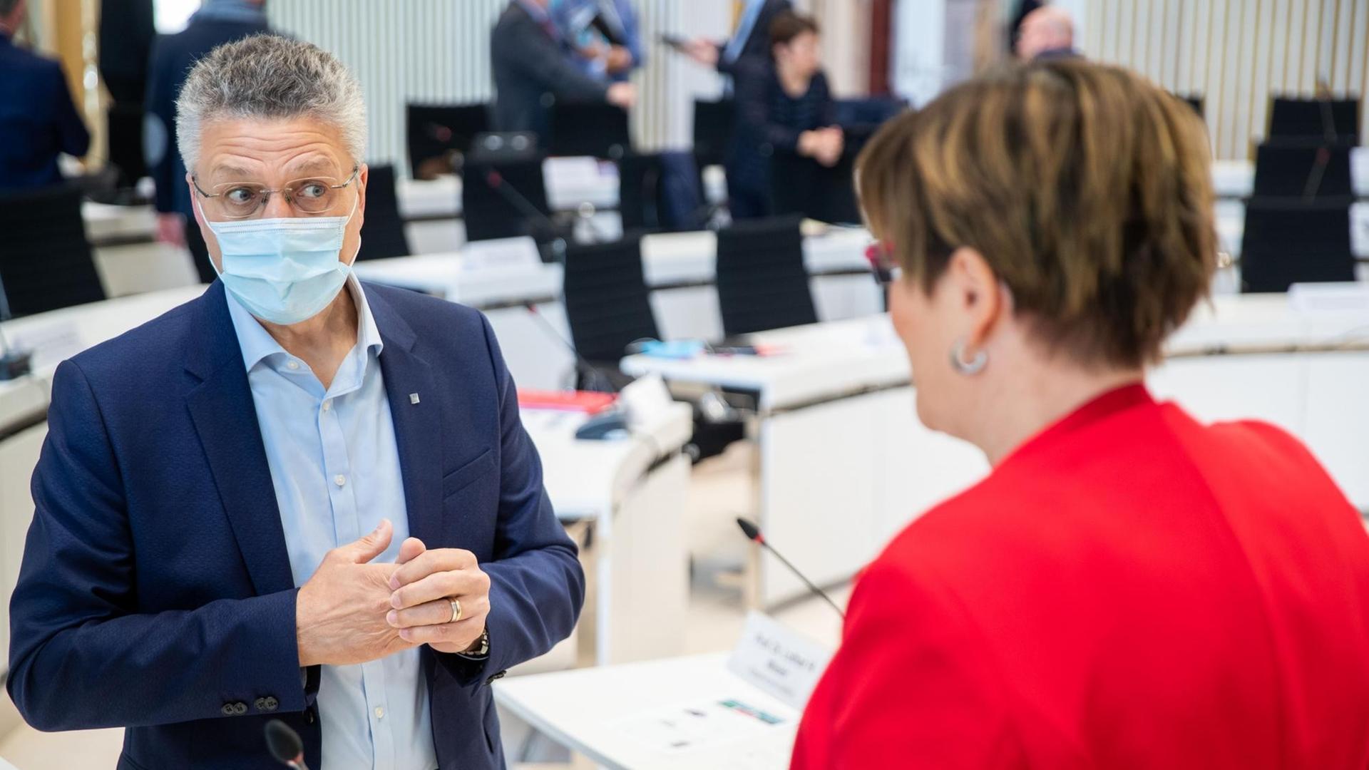 Der Präsident des Robert Koch-Instituts, Lothar Wieler, in Schwerin (Mecklenburg-Vorpommern) vor einer Beratung mit der Regierung und kommunalen Vertretern über die Corona-Pandemie. Wieler steht in einem Konferenzsaal, spricht mit einer Frau in rotem Blazer und trägt einen Mundschutz. Der Präsident des Robert Koch-Instituts, Lothar Wieler, in Schwerin (Mecklenburg-Vorpommern) vor einer Beratung mit der Regierung und kommunalen Vertretern über die Corona-Pandemie. Wieler steht in einem Konferenzsaal, spricht mit einer Frau in rotem Blazer und trägt einen Mundschutz.