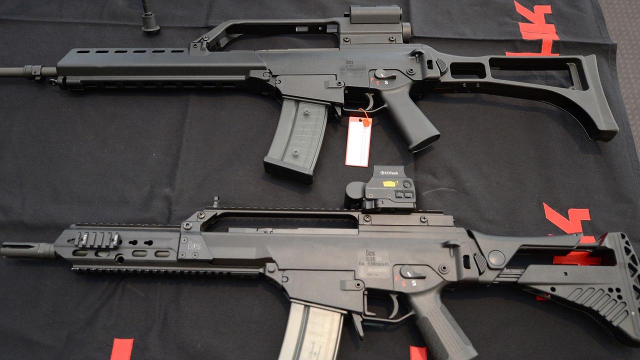 Zwei Sturmgewehre G36 von Heckler und Koch liegen am 07.05.2015 in Oberndorf in der Firmenzentrale auf einem Tisch vor einem Logo des Waffenproduzenten.