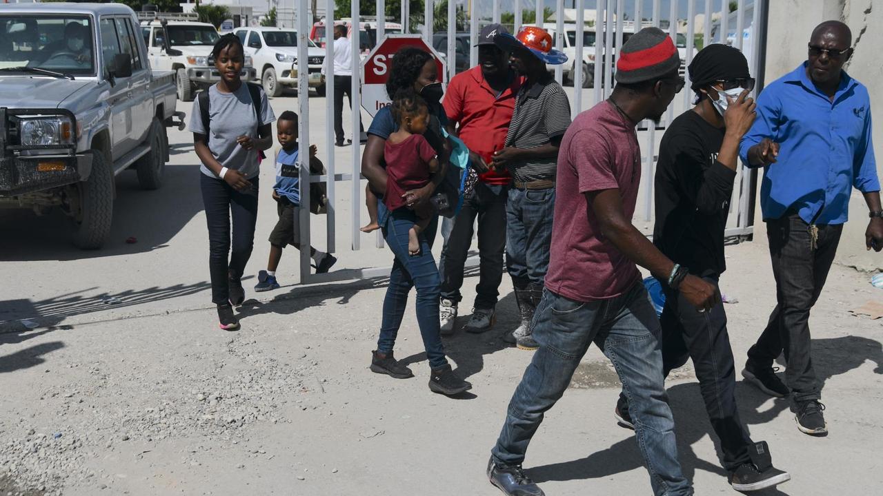 Mehrere Personen bei der Ankunft der Abgeschobenen am Flughafen Port-au-Prince.