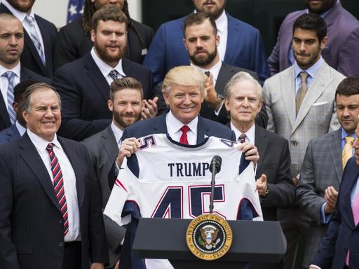 US-Präsident Donald Trump hält ein maßgeschneidertes Trikot hoch, das ihm vom Super-Bowl-Champion 2017, den New England Patriots, bei ihrem Besuch im Weißen Haus in Washington überreicht wurde.