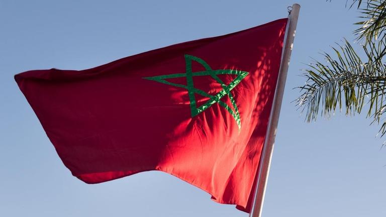 Eine marokkanische Flagge weht auf dem Flughafen in Marrakesch im Wind Eine marokkanische Flagge weht auf dem Flughafen in Marrakesch im Wind