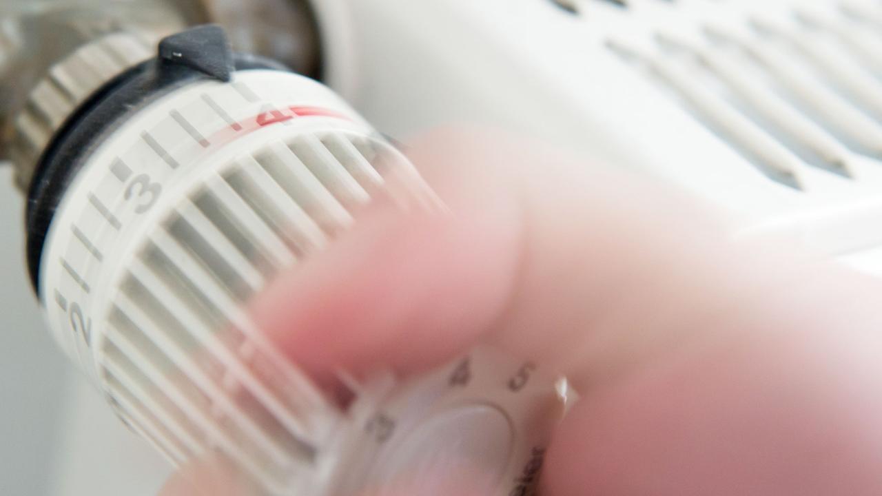 Jemand dreht an einem Thermostat eines Heizkörpers. Jemand dreht an einem Thermostat eines Heizkörpers.