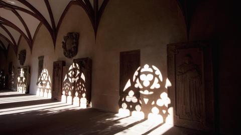 Schatten der Fensterarchitektur auf dem Boden und den Wänden des Kreuzganges.
