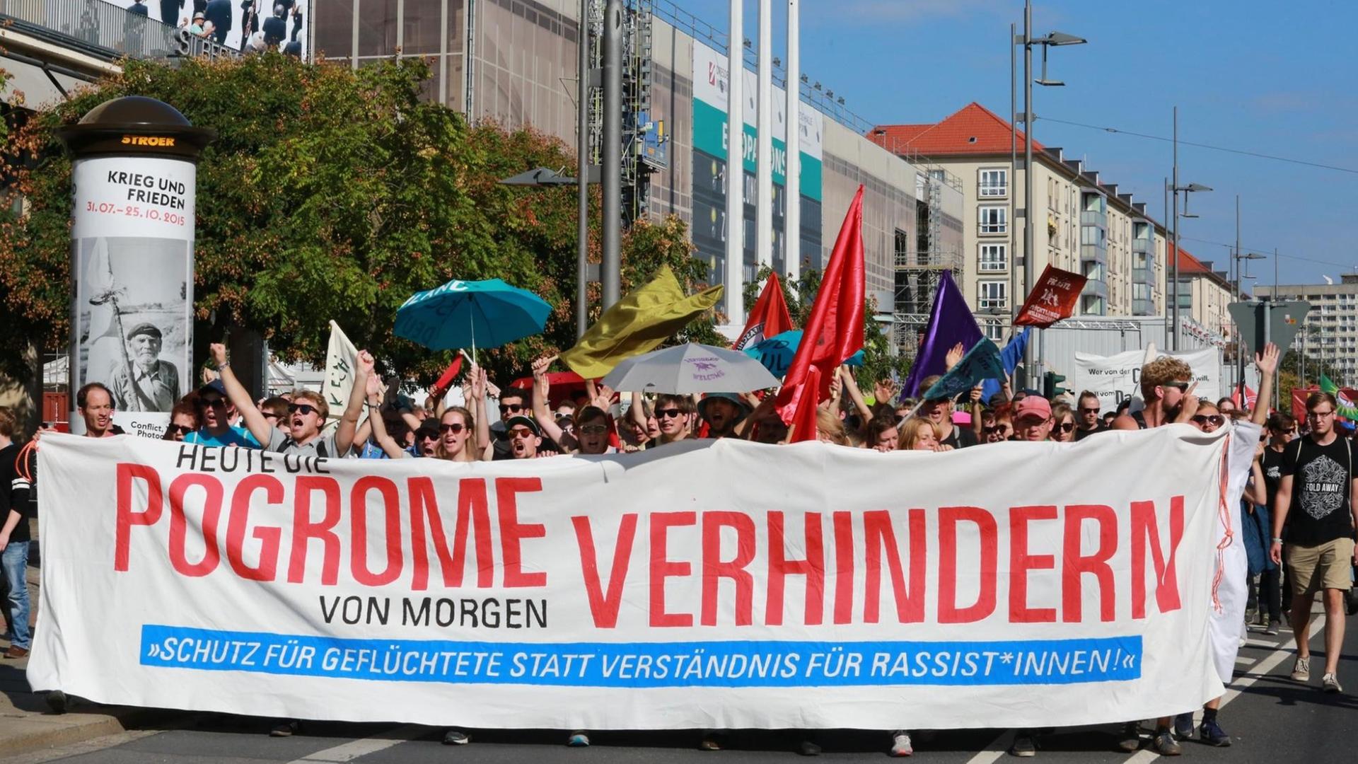 Demonstranten tragen ein Banner mit der Aufschrift: "Heute die Pogrome von morgen verhindern." Demonstranten tragen ein Banner mit der Aufschrift: "Heute die Pogrome von morgen verhindern."