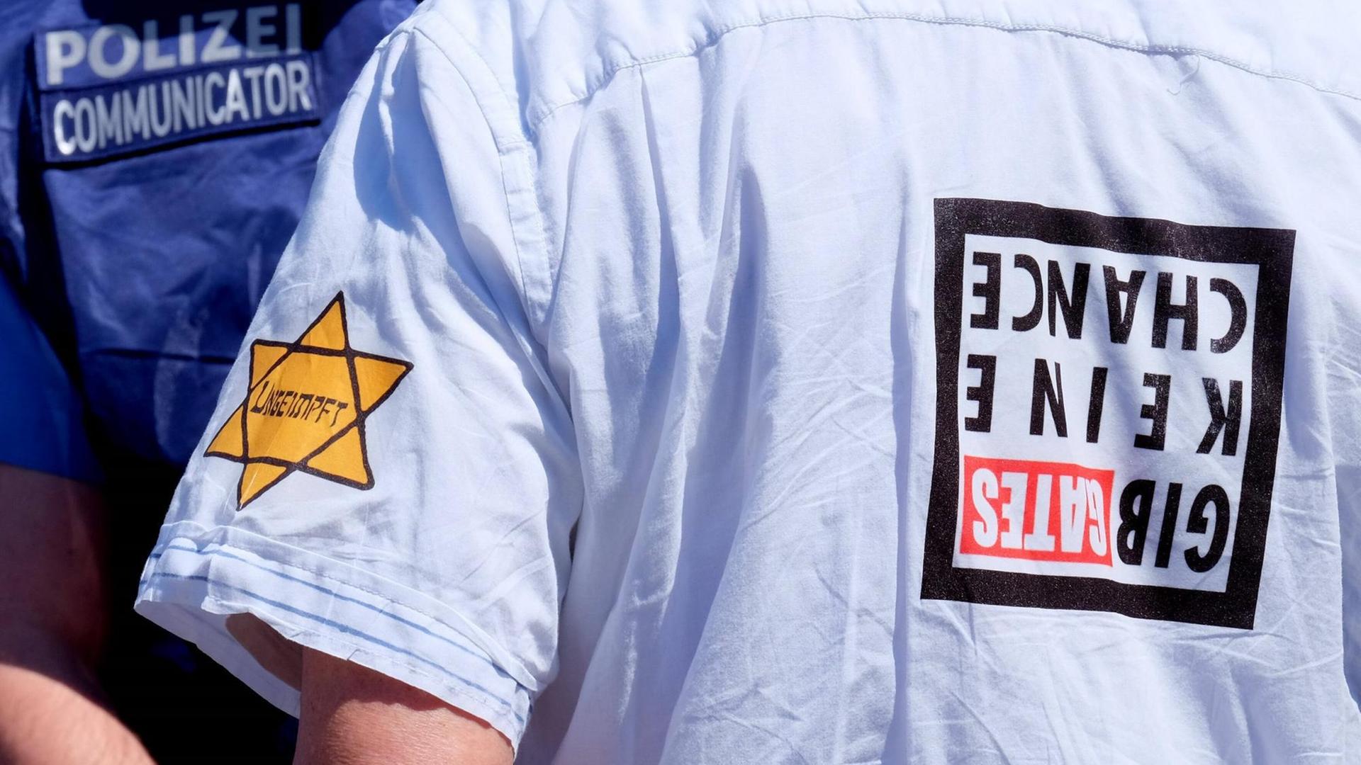 16.05.2020, Frankfurt, DEU Demonstration in der Frankfurter Innenstadt. Ungeimpft steht auf dem Aufkleber am Arm eines Mannes, der versucht hat, sich unter die Teilnehmer einer Demonstration zu mischen, die die Verschwoerungstheorien ueber das Corona Virus ablehnt 16.05.2020, Frankfurt, DEU Demonstration in der Frankfurter Innenstadt. Ungeimpft steht auf dem Aufkleber am Arm eines Mannes, der versucht hat, sich unter die Teilnehmer einer Demonstration zu mischen, die die Verschwoerungstheorien ueber das Corona Virus ablehnt