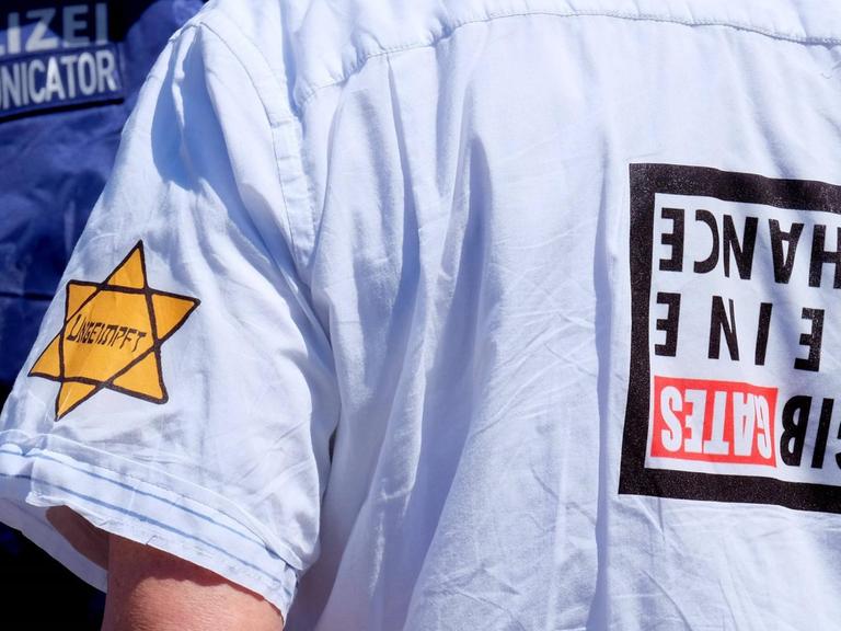 16.05.2020, Frankfurt, DEU Demonstration in der Frankfurter Innenstadt. Ungeimpft steht auf dem Aufkleber am Arm eines Mannes, der versucht hat, sich unter die Teilnehmer einer Demonstration zu mischen, die die Verschwoerungstheorien ueber das Corona Virus ablehnt