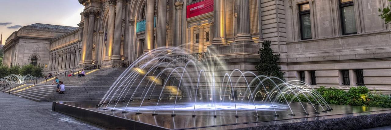 Das Metropolitan Museum Of Art in New York mit Fontänenspiel vor dem Haupteingang in der Dämmerung. 