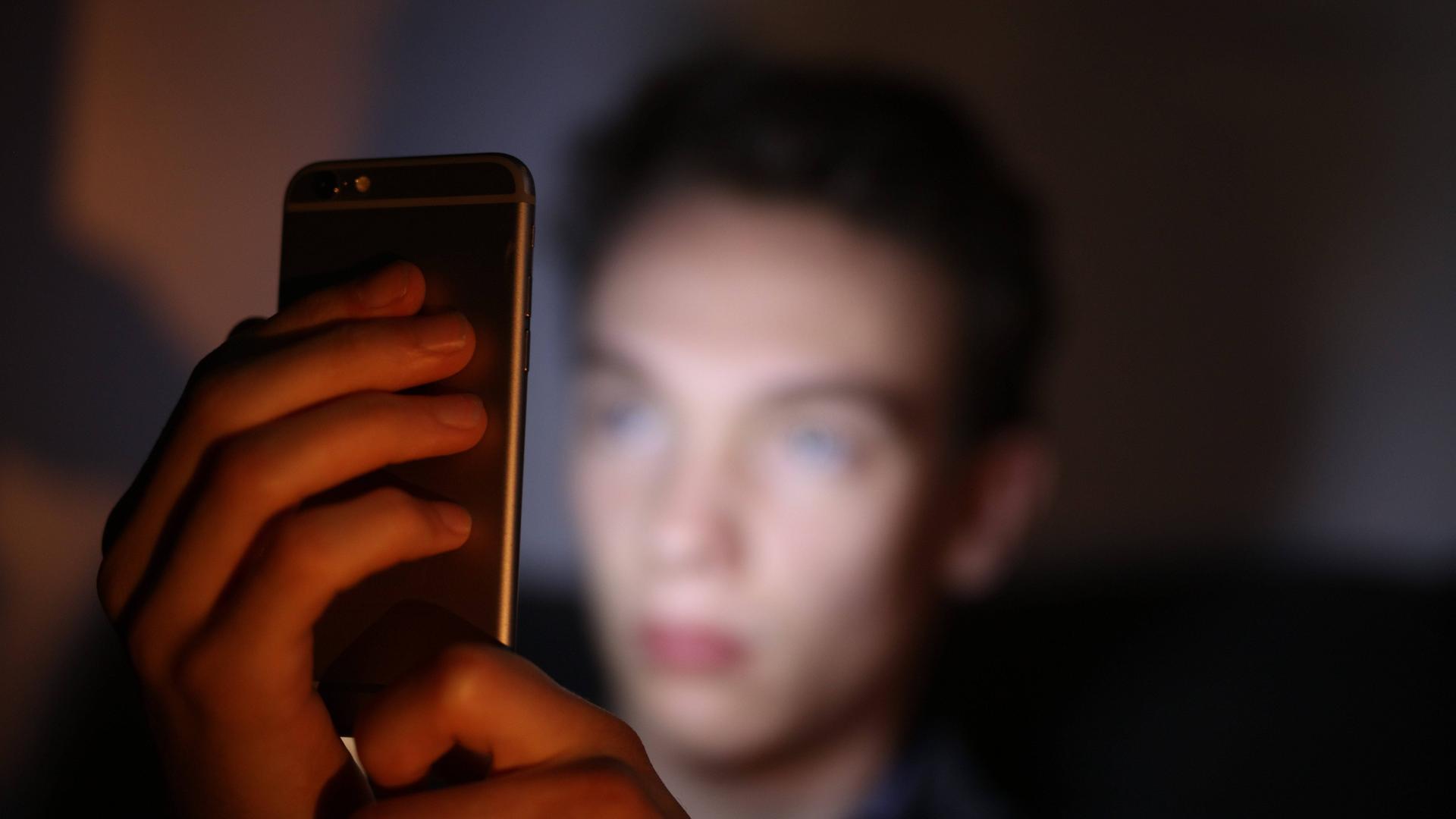 Ein Jugendlicher schaut auf sein Smartphone (Symbolbild)