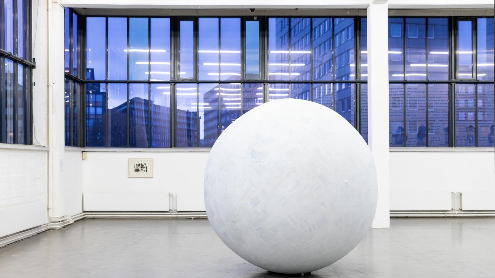 Ein weiße, große Kugel steht vor den nachtblauen Fenstern des Kunstvereins Hamburg Ein weiße, große Kugel steht vor den nachtblauen Fenstern des Kunstvereins Hamburg