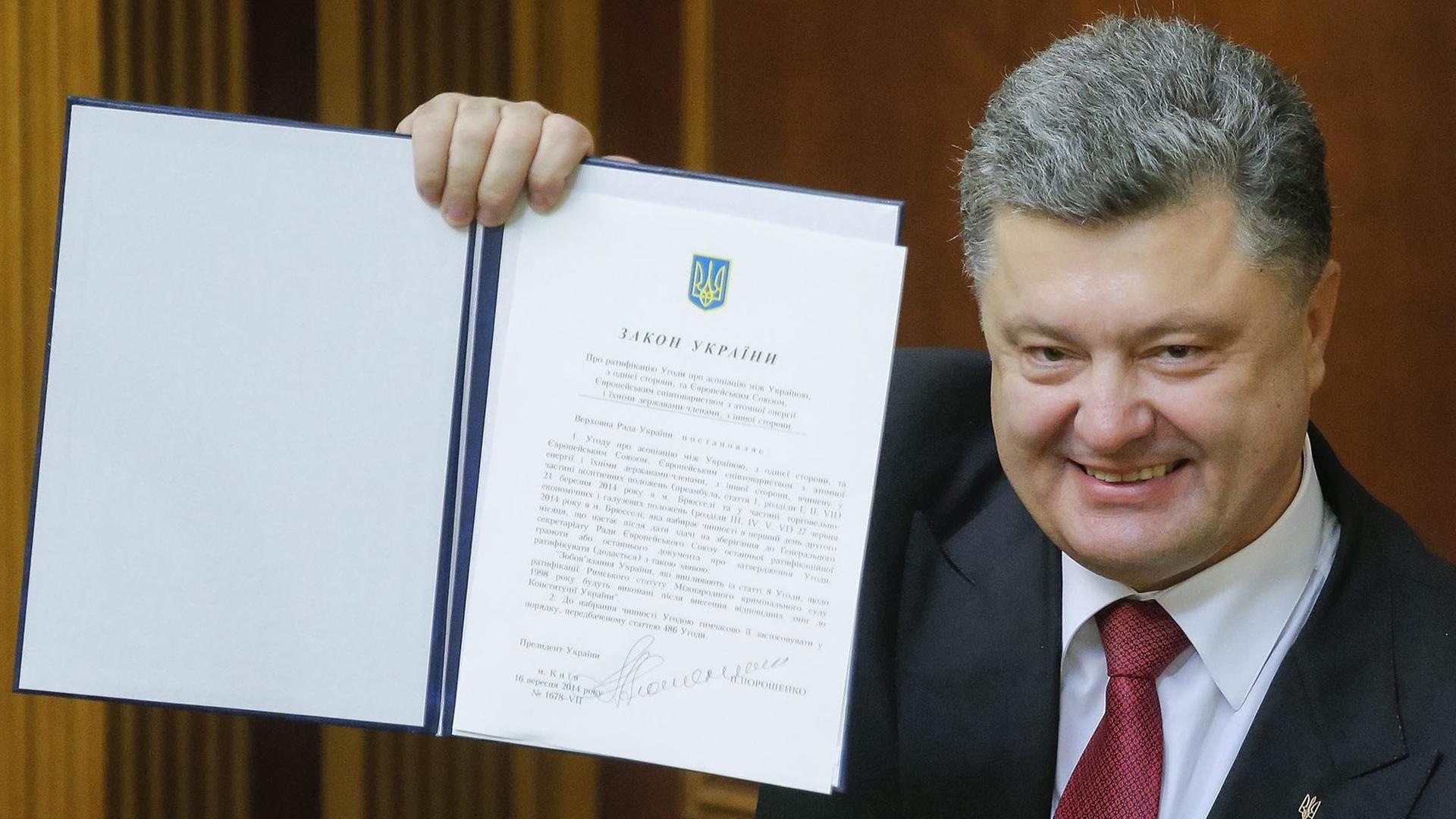 Petro Poroschenko hält das unterzeichnete EU-Partnerschaftsabkommens hoch. Petro Poroschenko hält das unterzeichnete EU-Partnerschaftsabkommens hoch.