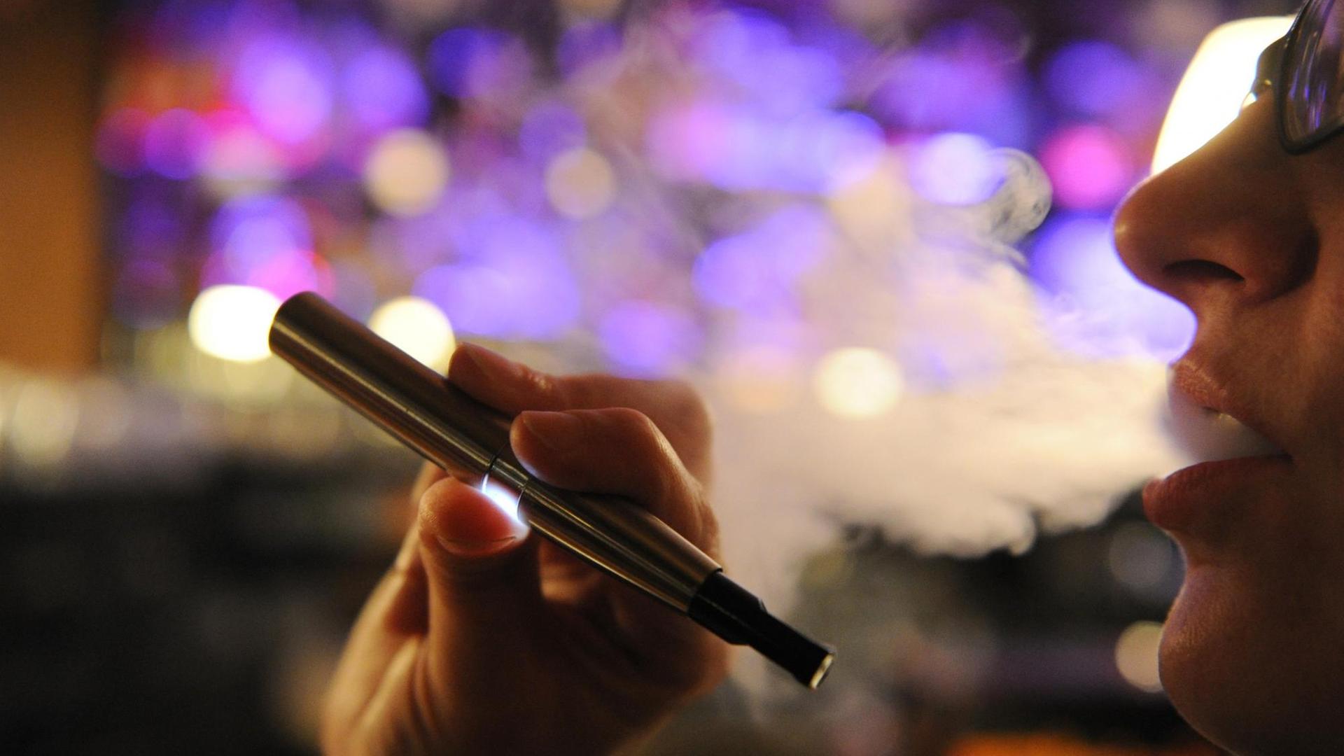 Eine Frau raucht in Hamburg eine elektrische Zigarette. Die elektronische Zigarette wird als "gesunde Alternative" zum Rauchen gehandelt, da sie keinen Tabak verbrennt. Kritiker warnen aber davor, die Auswirkungen des E-Glimmstängels zu unterschätzen.