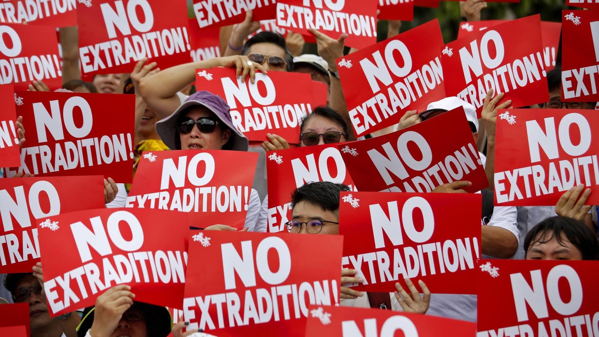 Demonstranten in Hongkong halten Plakate in die Höhe mit der Aufschrift: "No Extradition!" (Keine Auslieferung) anlässlich einer Kundgebung gegen das von der Regierung geplante Auslieferungsgesetz.