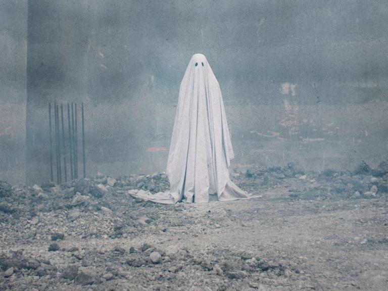Figur mit Bettlaken und Schlitzen für die Augen als Gespenst. Der Schauspieler Casey Affleck in dem US-amerikanischen Spielfilm "A Ghost Story" aus dem Jahr 2017