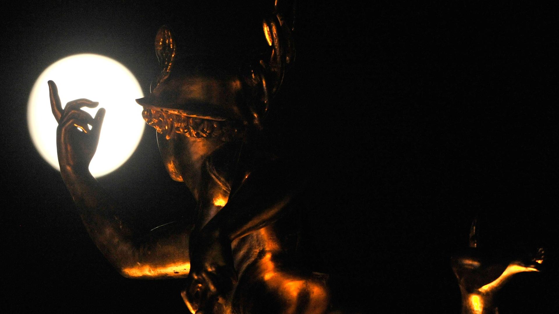 Die Statue des Merkur auf der Alten Kanzlei in Stuttgart scheint nach dem Mond zu greifen. Die Statue des Merkur auf der Alten Kanzlei in Stuttgart scheint nach dem Mond zu greifen.