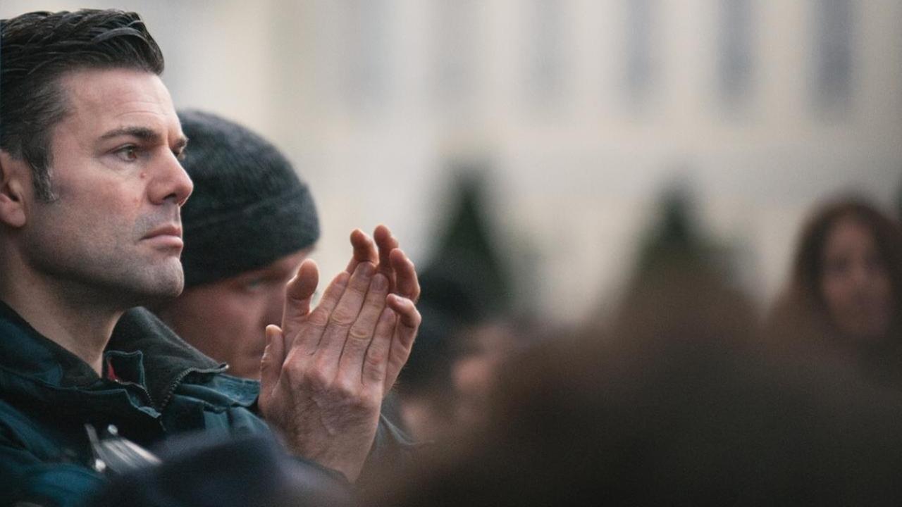 Ken Jebsen steht mit ernster Miene in einer Demonstration und klatscht. Ken Jebsen steht mit ernster Miene in einer Demonstration und klatscht.