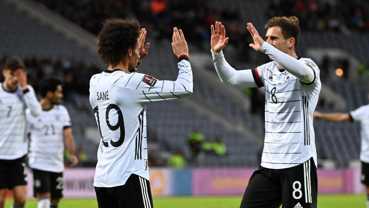 Die beiden Spieler klatschen sich auf dem Platz ab. Die beiden Spieler klatschen sich auf dem Platz ab.