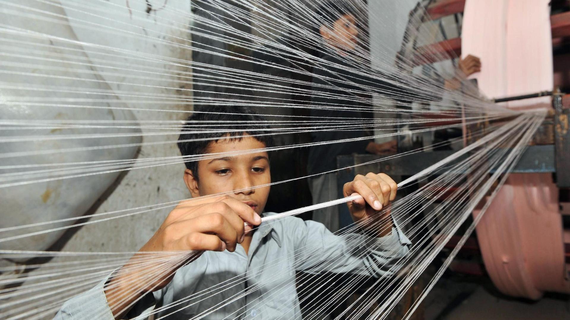 Ein Junge in einer Textilfabrik in Lahore, Pakistan.