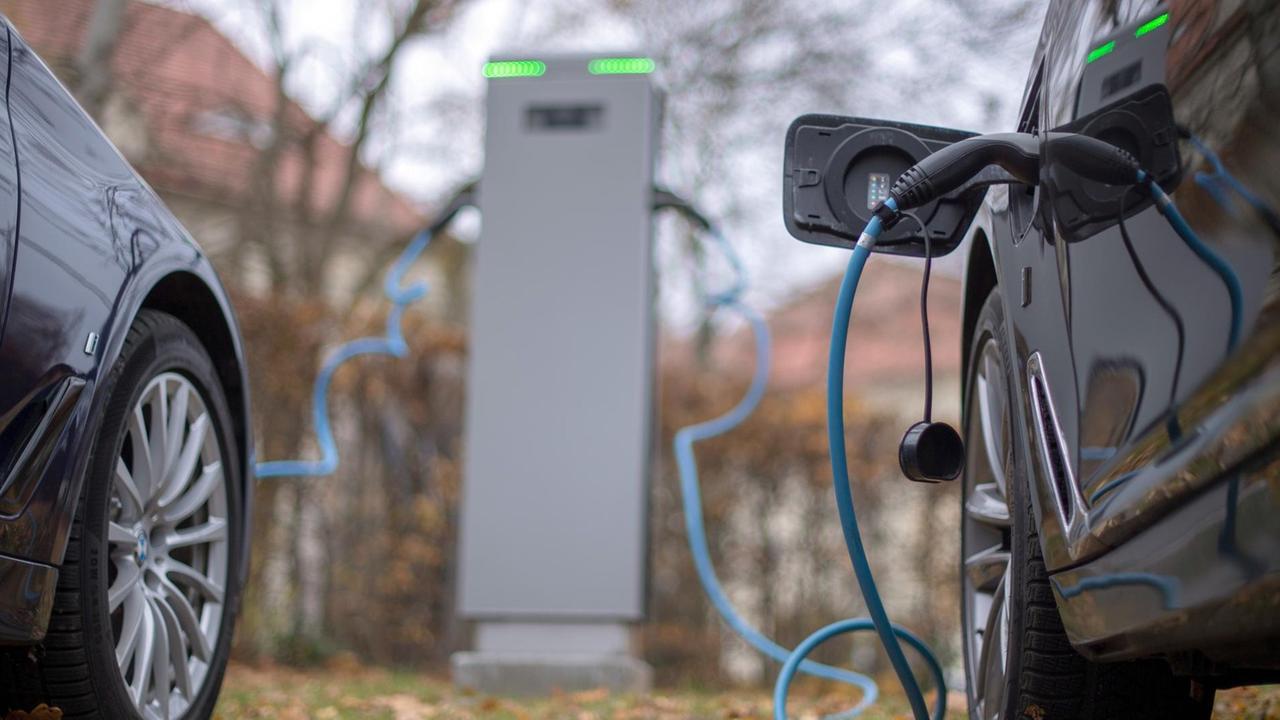 Zwei Elektroautos werden an einer Ladesäule geladen. Zwei Elektroautos werden an einer Ladesäule geladen.