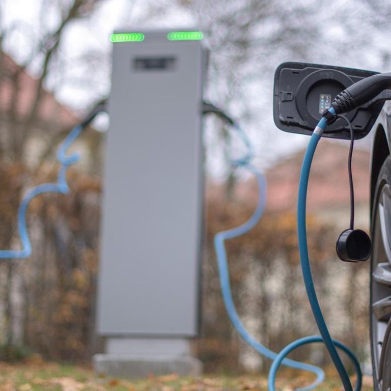 Zwei Elektroautos werden an einer Ladesäule geladen. 