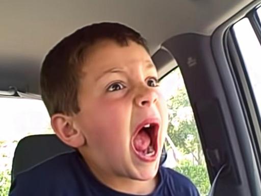 Szene aus »David after Dentist«. Das Bild zeigt einen Jungen mit einem weit aufgerissenen Mund auf der Rückbank eines Autos sitzend.
