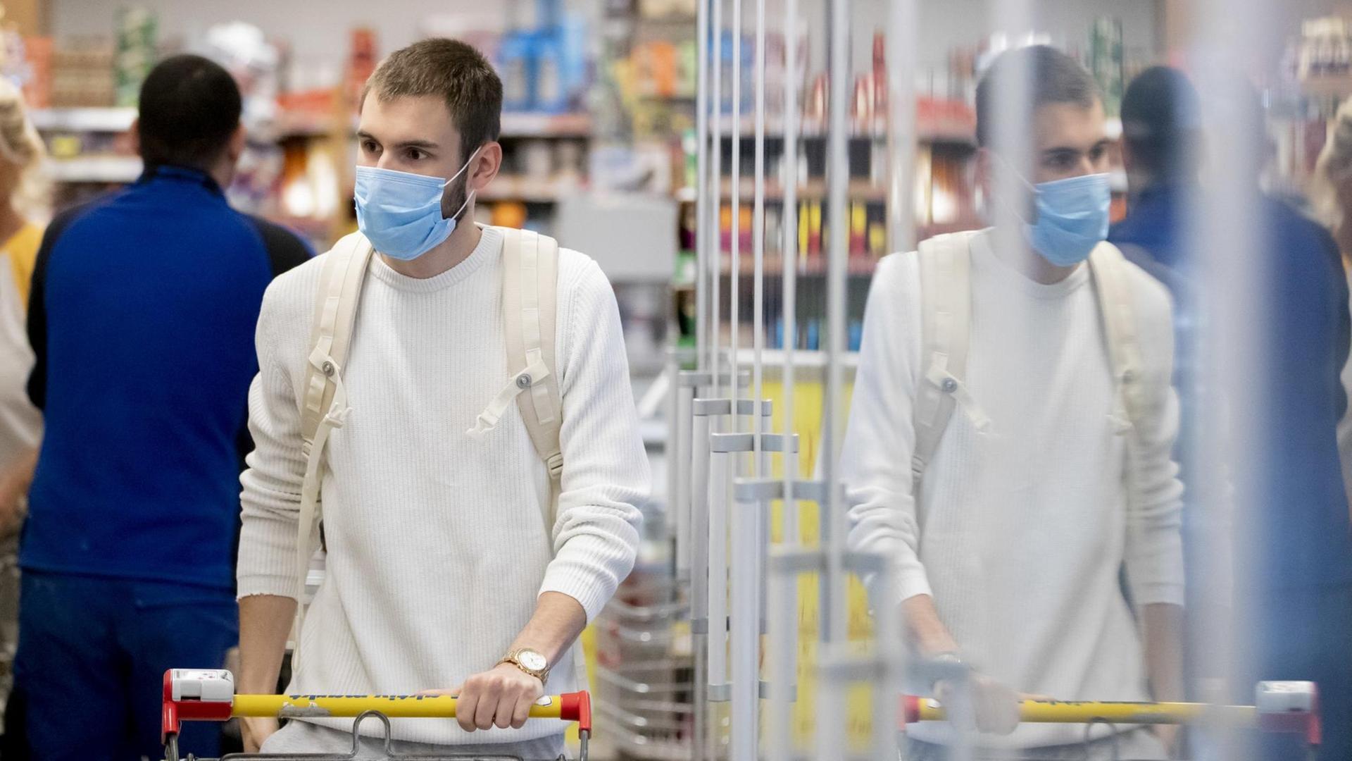 Ein Kunde geht in einem Supermarkt in Berlin-Wilmersdorf mit Mund-Nasen-Schutz einkaufen. Ein Kunde geht in einem Supermarkt in Berlin-Wilmersdorf mit Mund-Nasen-Schutz einkaufen.