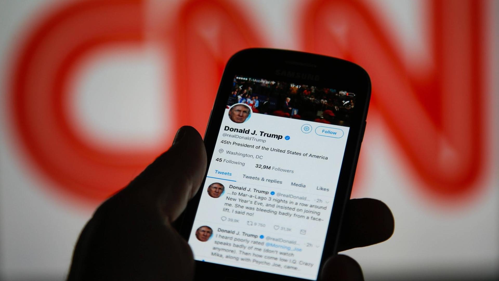 Donald Trumps Twitter-Meldungen auf einem Smartphone. Im Hintergrund das Logo von CNN. Trump postete ein Video, das ihn in einem Wrestlingkampf zeigt, wobei sein Opfer durch ein CNN-Logo ersetzt wurde. Donald Trumps Twitter-Meldungen auf einem Smartphone. Im Hintergrund das Logo von CNN. Trump postete ein Video, das ihn in einem Wrestlingkampf zeigt, wobei sein Opfer durch ein CNN-Logo ersetzt wurde.