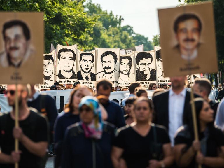 Demonstranten halten bei einer Kundgebung in München Schilder mit Porträts der NSU-Opfer.
