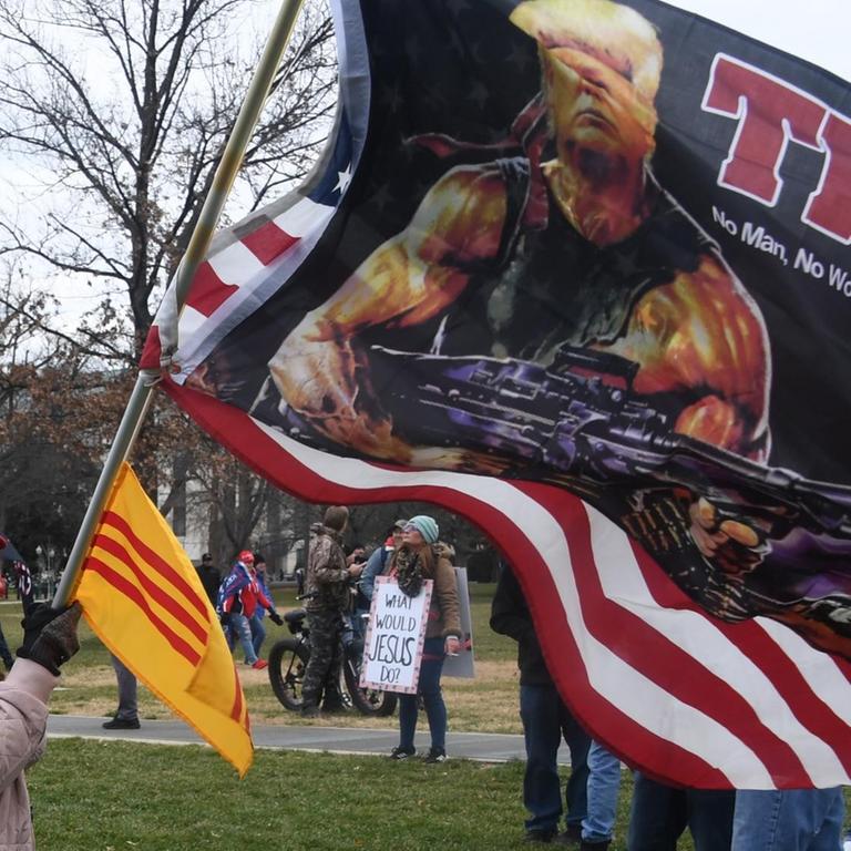 Trump-Unterstützer trägt Fahne mit Trump als Waffenträger