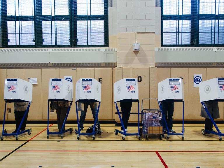Wähler geben in einem Wahllokal in New York ihre Stimmen an Wahlcomputern ab.