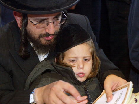 Ein Chasside und sein kleiner Sohn beten in einem Gebetshaus in der Nähe des Grabes von Rabin Nachman in der kleinen ukrainischen Stadt Uman. Ein Chasside und sein kleiner Sohn beten in einem Gebetshaus in der Nähe des Grabes von Rabin Nachman in der kleinen ukrainischen Stadt Uman.