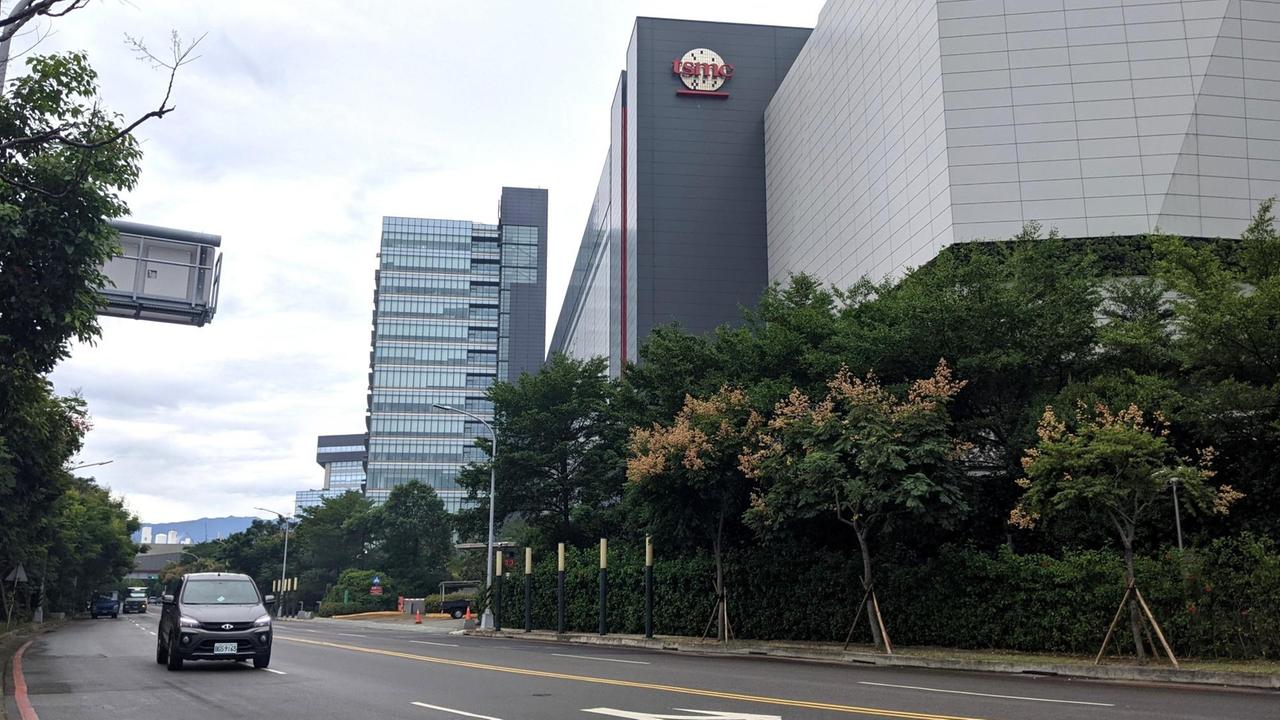 Eine Halbleiter-Fabrik im Technologiepark von TSMC in Hsinchu: graues Gebäude, neben der Straße, oben ist das Logo zu erkenn. Eine Halbleiter-Fabrik im Technologiepark von TSMC in Hsinchu: graues Gebäude, neben der Straße, oben ist das Logo zu erkenn.